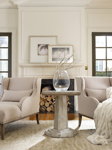 Comfortable neutral upholstered chaises flank the Colonnade Accent Table from Hooker Furniture’s Melange collection. A white, faux fur throw lends a snow-like quality to the scene.